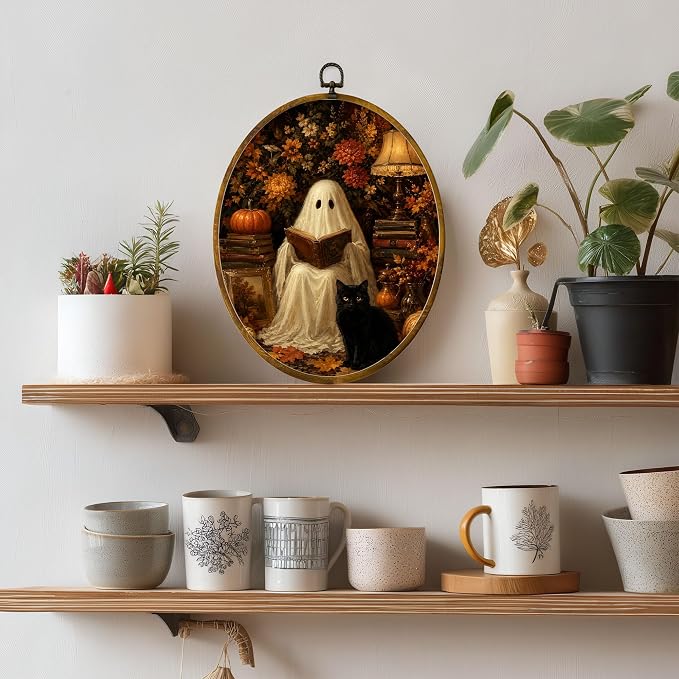 Reading Ghost Black Cat Oval Wall Art, Framed Canvas Decor, 8.5x11.5 Inch | Reading ghost with black cat, pumpkins, autumn flowers and cozy lamp decor